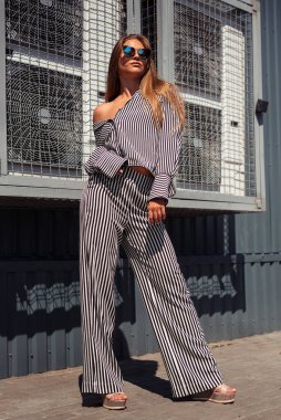 Aşağıdan bir kızın fotoğrafı. Kız tek ayak üzerinde duruyor. Bir kızın tam boy fotoğrafı. Tasarımcı kavramı.