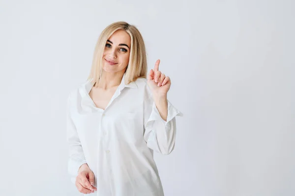 Una Chica Pelo Rubio Levanta Sobre Fondo Blanco Señala Con —  Fotos de Stock