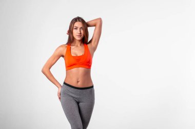 Eşofmanlı, kum saati gibi beli ve beyaz arka planda eli olan bir kız..