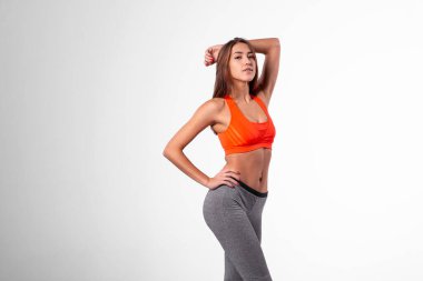 Brunette in a tracksuit with a flat stomach on a white background. Go to workout