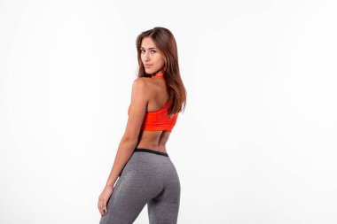 Eşofmanlı esmer kadın beyaz arka planda izole edilmiş. Eşofmanlı, arkana bak. Kilo verme konsepti.