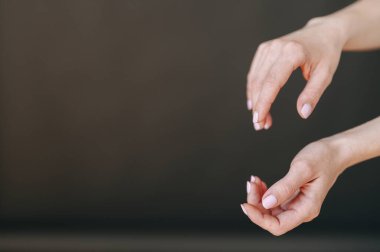 Siyah arka planda, sağ taraftaki kadın ellerinin yakın çekimi. El bakımı konsepti, temiz eller, el kremi