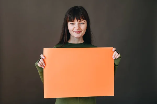 Joyful Young Girl Looks Camera Holds Orange Paper Her Hands — Φωτογραφία Αρχείου