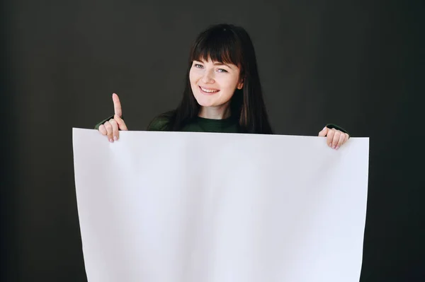 Horizontal Photo Girl Who Holds White Paper Her Hands Points — Φωτογραφία Αρχείου