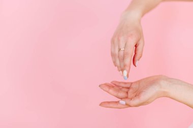 Güzel manikür ve altın yüzüklü pembe arka plana odaklan..