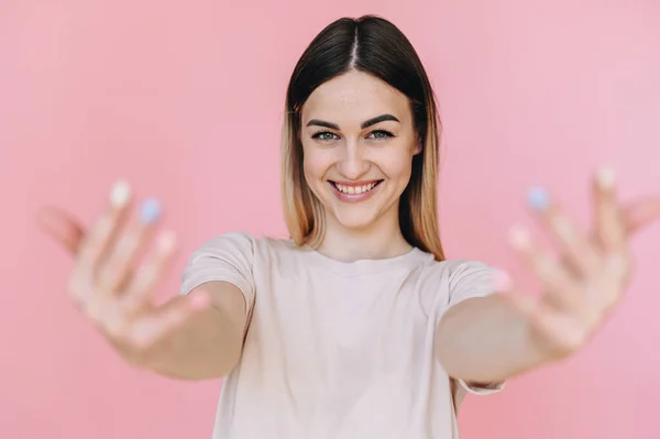 Young Woman Looks Camera Puts Her Hands Forward Showing Multi — Stock fotografie