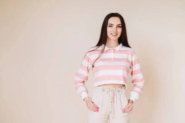 Μια Φοιτήτρια Καθημερινά Ρούχα Στέκεται Κοντά Ένα Μπεζ Τοίχο Και — Φωτογραφία Αρχείου