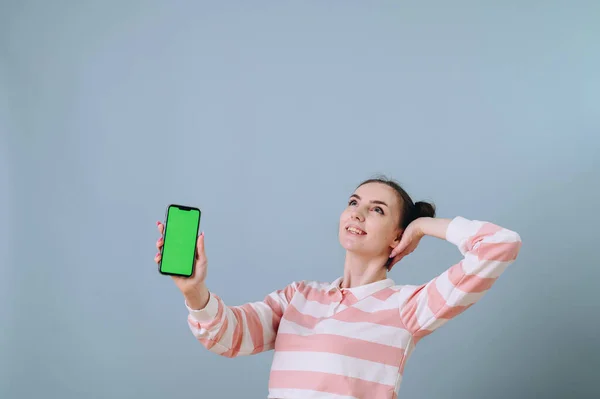 Dívka Sní Ukazuje Zelenou Obrazovku Telefonu Izolovaném Pozadí Ruku Dobu — Stock fotografie