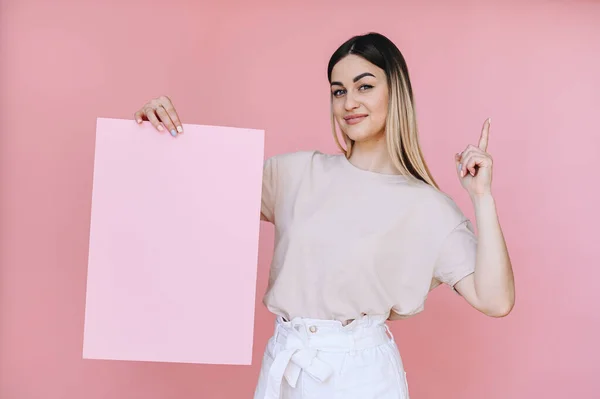 Dziewczyna Trzyma Kartkę Różowego Papieru Prawej Ręce Palec Wskazujący Wskazuje — Zdjęcie stockowe