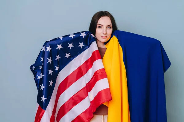 両側に覆われたアメリカとウクライナの旗を持つ美しくスマートな女の子の肖像画 アメリカの概念はウクライナを助ける — ストック写真