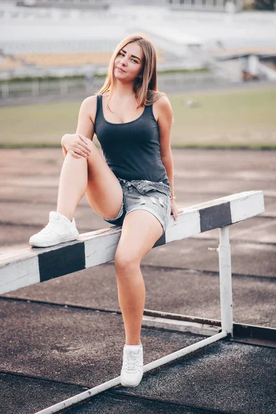 Atleta Sienta Obstáculo Zapatillas Blancas Estadio Con Una Sonrisa Cara — Foto de Stock