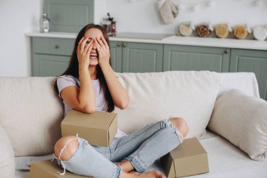 Kafkasyalı kız mutfakta kanepede oturur ve ellerini çılgınca gülerek gözlerini kapatır, Provencal mutfağı. Paket paketleme kavramı.