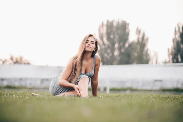 Šťastná Žena Sedící Trávě Pronikavě Zírá Kameru Pohled Zepředu Západ — Stock fotografie