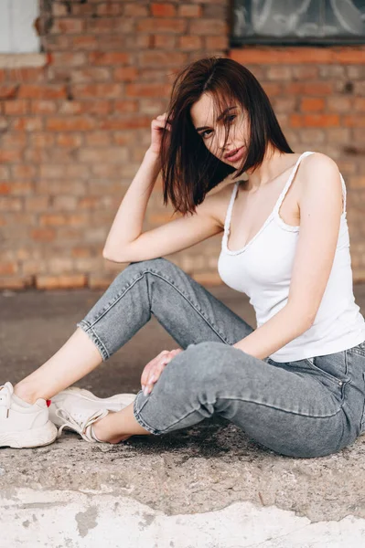 Vertical portrait of a girl with a short haircut. Hair develops from the wind. Warm summer evening.