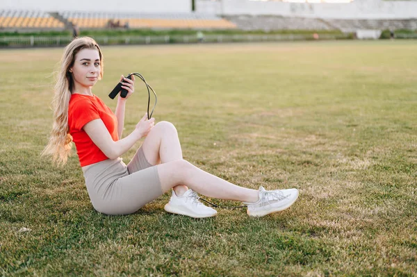 Ragazza Seduta Sul Prato Con Corda Salto Nelle Sue Mani — Foto Stock