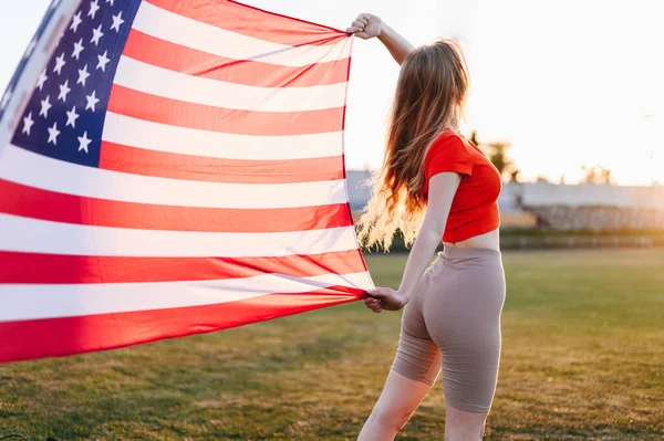 Μια Αμερικανίδα Αθλήτρια Αμερικανική Σημαία Στο Ηλιοβασίλεμα Αναπτύσσεται Στον Άνεμο — Φωτογραφία Αρχείου