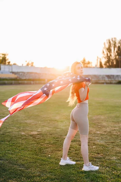 Атлетична Жінка Стоїть Повному Зростанні Проти Сонця Тримає Американський Прапор — стокове фото