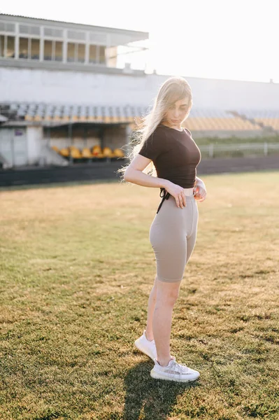 Jonge Atletische Vrouw Die Naar Beneden Kijkt Haar Benen Aanpast — Stockfoto