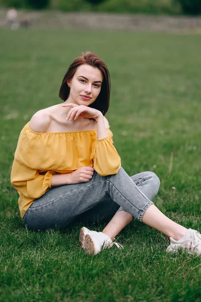 Młoda Kobieta Siedzi Żółtej Bluzce Trawie Kobieta Skrzyżowanymi Nogami Odpoczywająca — Zdjęcie stockowe