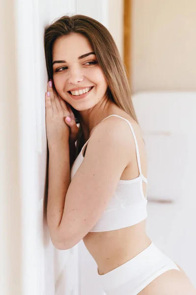 Beyaz Duvar Yaslanmış Kafkasyalı Rahat Genç Bayan Yüzünde Gülümsemeyle Evinde — Stok fotoğraf