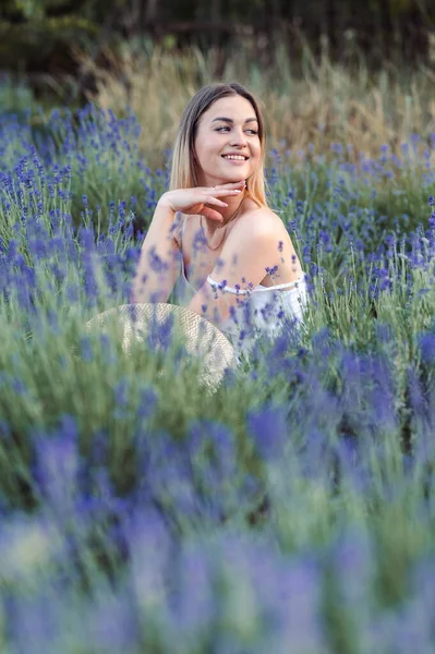 Portrait of a Young Blonde Woman in a Lavender Meadow Smiling and Looking Away. Healing properties of lavender. Lavender For Cosmetology