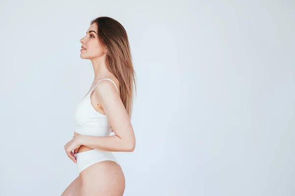 Junge Frau Weiße Unterwäsche Die Seitlich Auf Weißem Hintergrund Steht — Stockfoto
