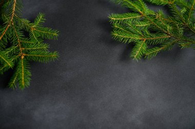 Metnin Altında Boş Alan ile Noel Ekran Koruyucusu. Kenarları Yeşil Ağaç Dallarıyla Karanlık Boş Masa