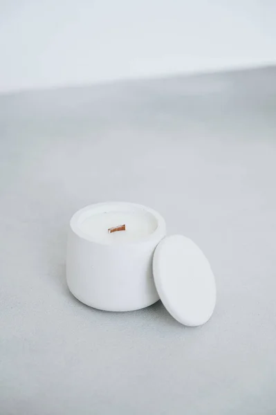 Candle with Natural Soy Wax. Candle in Plaster Mold with Wooden Wick. Interior Candle on Gray Table. Creating Comfort. Side view.