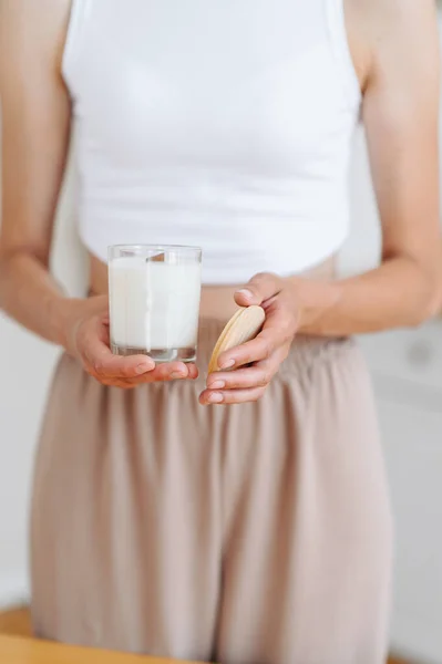Woman Light Clothes Holds Soy Candle Her Hands Glass Wooden — Stok Foto