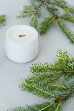 Yeşil Noel ağacı dalları arasında Beton Arka plan 'da Soya Cila ile yakın plan Beyaz Mum. Etiket 'e yer var. Noel Konsepti.