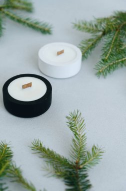 Beyaz Mum 'un ön görüntüsü. Yılbaşı ağacı dalları ve mumlar siyah ve beyaz yuvarlak şamdanlarda yatıyordu. Uzayı kopyala Noel Model Ekran Koruyucusu