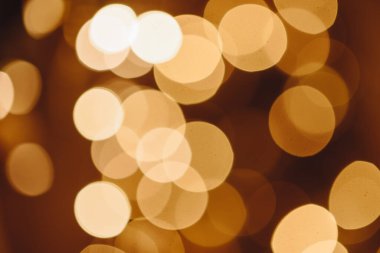 Circles of Bright Lights in in Dark. Black Background with Golden Light Effects. Horizontal Background with Blur Bokeh Effects for Christmas. Special Occasion Concept with Place for Text.