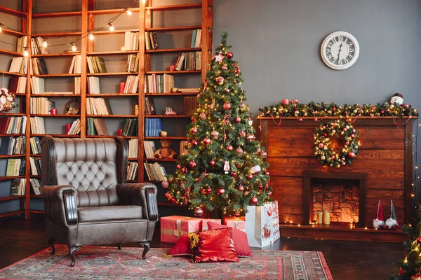 Yeni yıl arifesinde ve Noel 'de sıcak bir iç mekan. Şömine, Noel ağacı, Kol Sandalyesi ve Halı, Kitap Kütüphanesi. Kırmızı Noel Oyuncakları ve Hediyeleriyle Yeni Yıl Dekoru.
