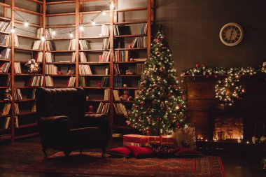 Christmas Tree Decorated with Golden Lights and Red Toys Presents Gifts, Candles, Mirror Garland Illuminating Fireplace. Holiday Living Room. New Year Holiday Concept