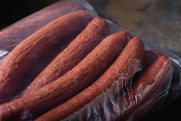 Large Sausages close-up in Vacuum Bag. Ready-made Meat Products for Supermarket. Place for label.