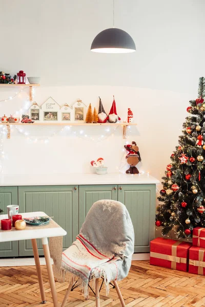 Cozy Provencal Kitchen on New Year's Eve with Christmas Tree, Gifts and Cute Christmas Decor. Light is on In Kitchen Above Table.