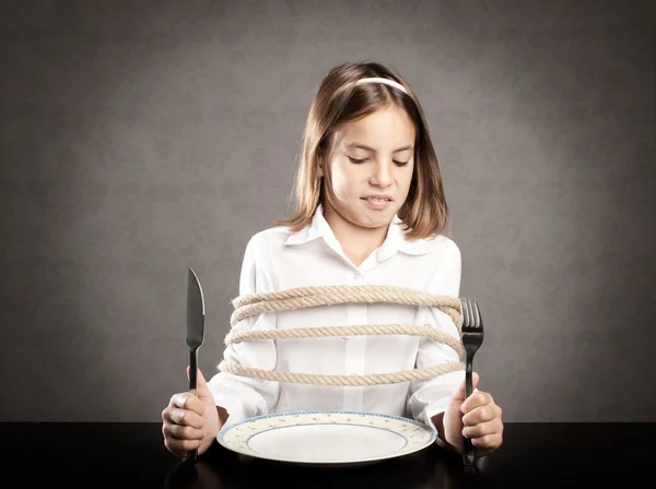 Dziewczyna roped siedział przy stole naprzeciwko danie — Zdjęcie stockowe
