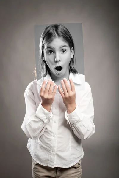 Dívka drží fotografii s výrazem překvapení — Stock fotografie