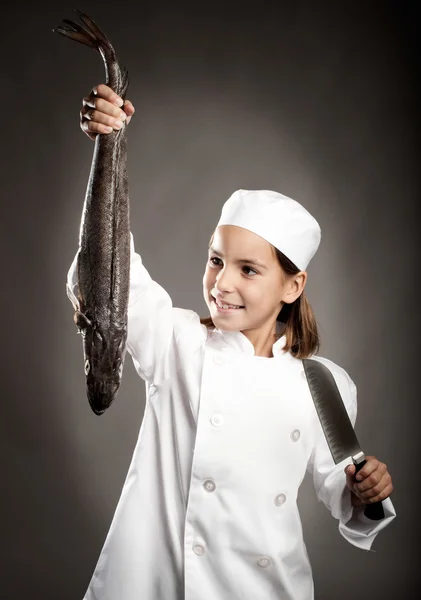 Kleine chef-kok houden een rauwe vis — Stockfoto