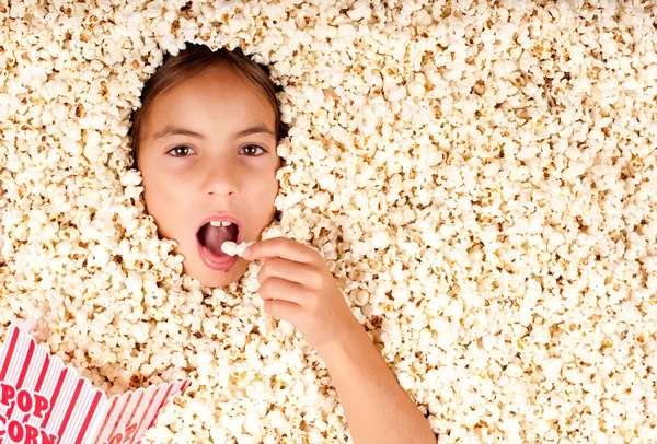 Liten flicka begravd i popcorn — Stockfoto