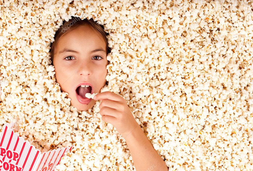 little girl buried in popcorn