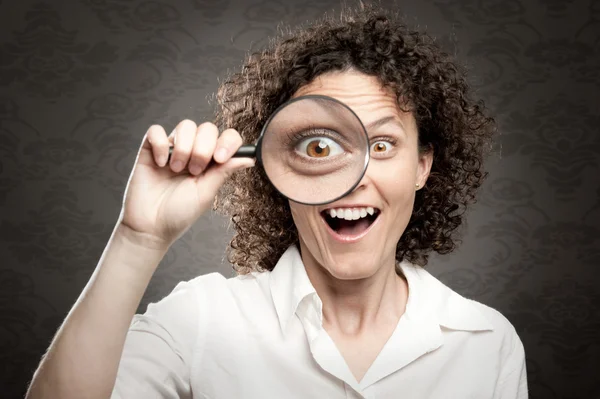 Woman looking through magnifying glass — Stock Photo, Image