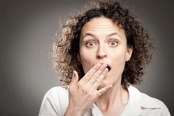 Woman with hand over mouth — Stockfoto