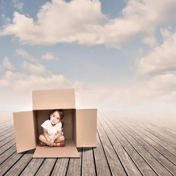 Маленькая девочка в коробке — стоковое фото