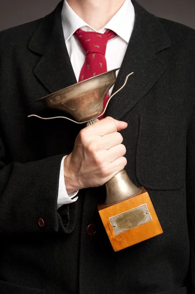 Empresário segurando um troféu — Fotografia de Stock