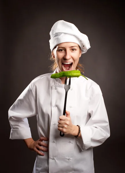 Woman chef holding a green pepper — Stock Photo, Image