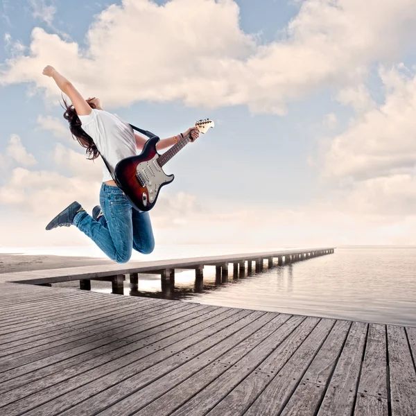 Teenager girl playing electric guitar on a wharf — Stock Photo, Image