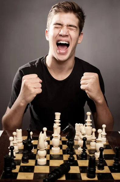 Młody człowiek świętuje zwycięstwo w szachach — Zdjęcie stockowe