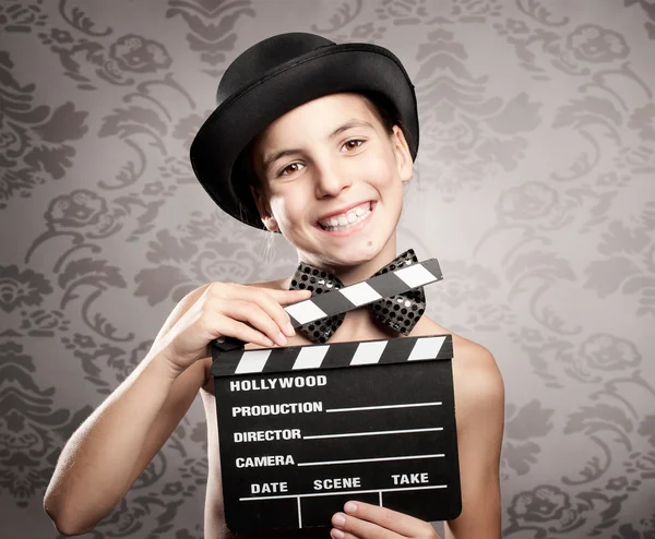 Glad liten flicka som håller en film kläpp — Stockfoto