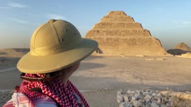 Mısır, Saqqara 'daki piramidin önünde duran kadının arka görüntüsü. Yüksek kalite fotoğraf
